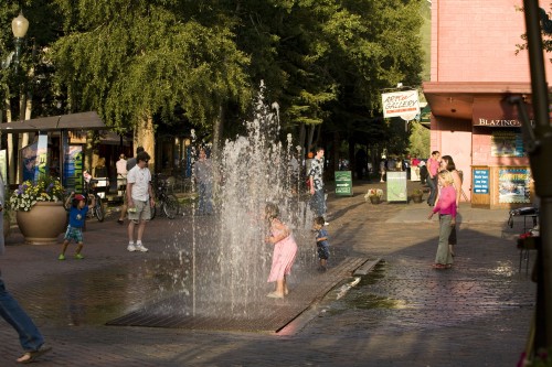 Little girl playing in the fountains in downtown Aspen near the Limelight Hotel Aspen.