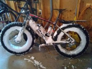 A fat tire bike covered in snow from riding during the winter in Aspen.