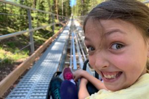 A girl waiting in anticipation of riding the Breathtaker Alpine Coaster at the Lost Forest adventure park at the Limelight Hotel Snowmass.