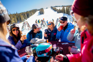 Best On-Mountain Dining Spots - A group of skiers enjoying a drink together