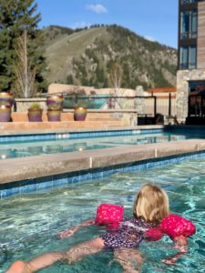Little girl with pink water wings swimming at the pool at the Limelight Hotel Ketchum.