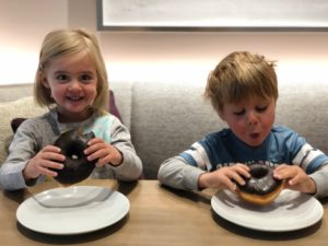 Two kids eating chocolate donuts at the Limelight Hotel Ketchum.