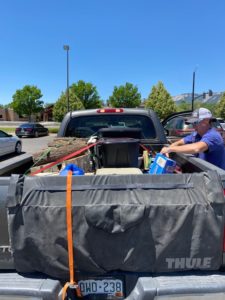 A person packing the bed of a pickup truck for a road trip.