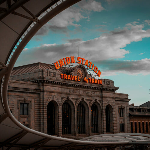 Denver's Union Station at sunset with neon sign illuminated.
